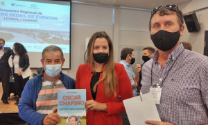 Fernanda Rodr&iacute;guez, directora nacional de Fiestas Populares, recibiendo el libro que recuerda a Oscar Chapino, de parte de Alejandro Comas y Dar&iacute;o Weglin.